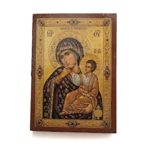 Close up of a handmade Panagia Paramythia Orthodox wooden mounted icon on a natural wood surface.