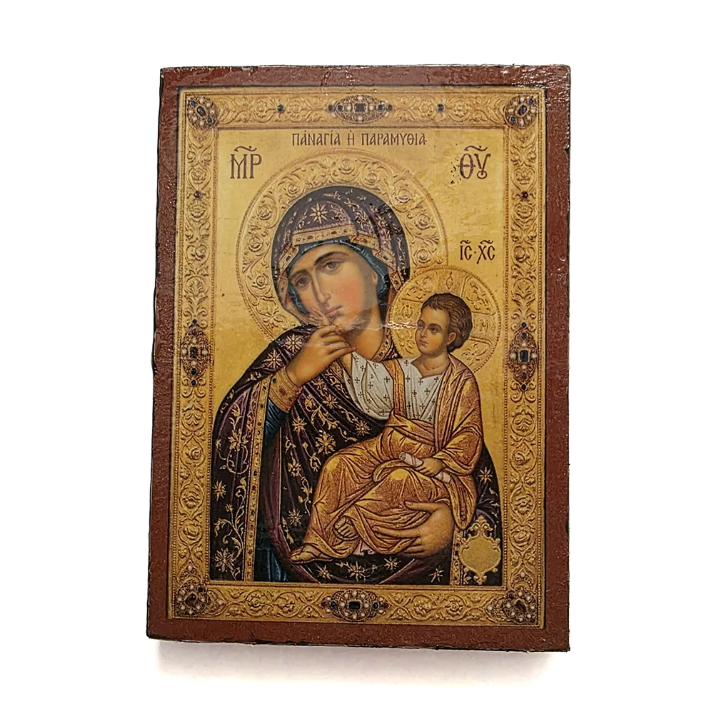 Close up of a handmade Panagia Paramythia Orthodox wooden mounted icon on a natural wood surface.