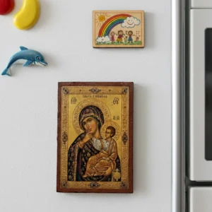 Close up of a handmade Panagia Paramythia Orthodox wooden mounted icon on a natural wood surface with magnet.