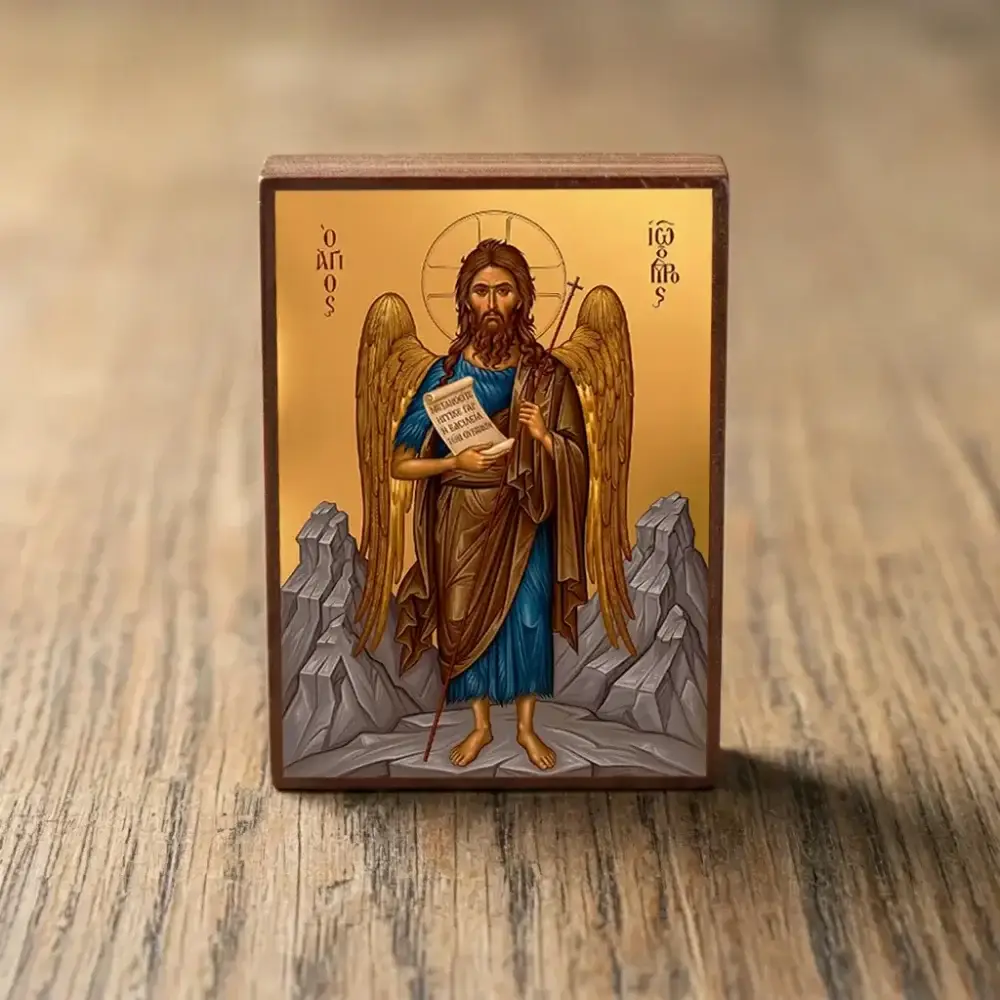 Saint John the Forerunner Byzantine wooden icon with wings and scroll, displayed on a wooden surface
